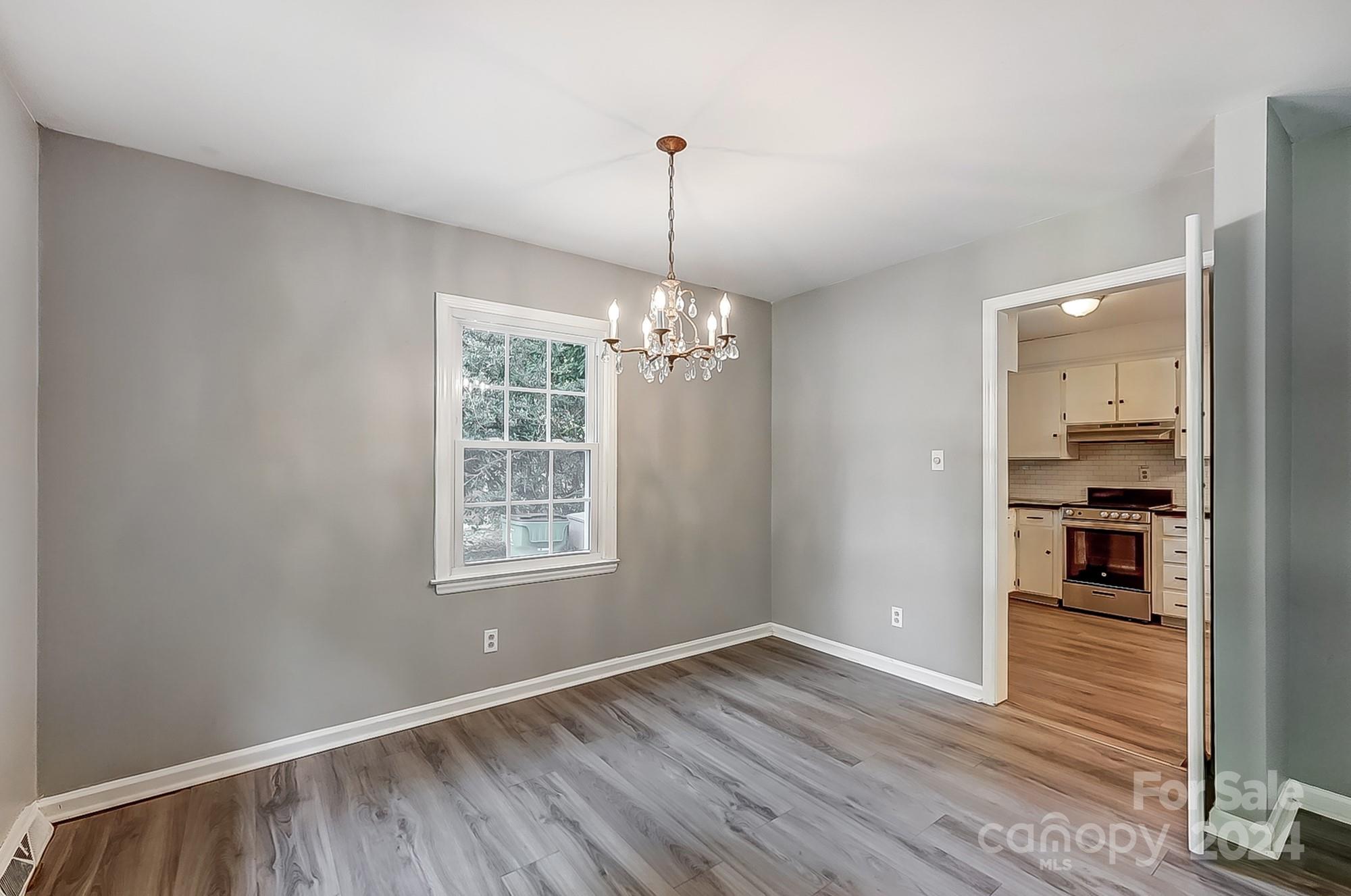 3218 Valley Grove Road Charlotte, NC 28227 - Photo 4 of 23 a view of an empty room with window and wooden floor