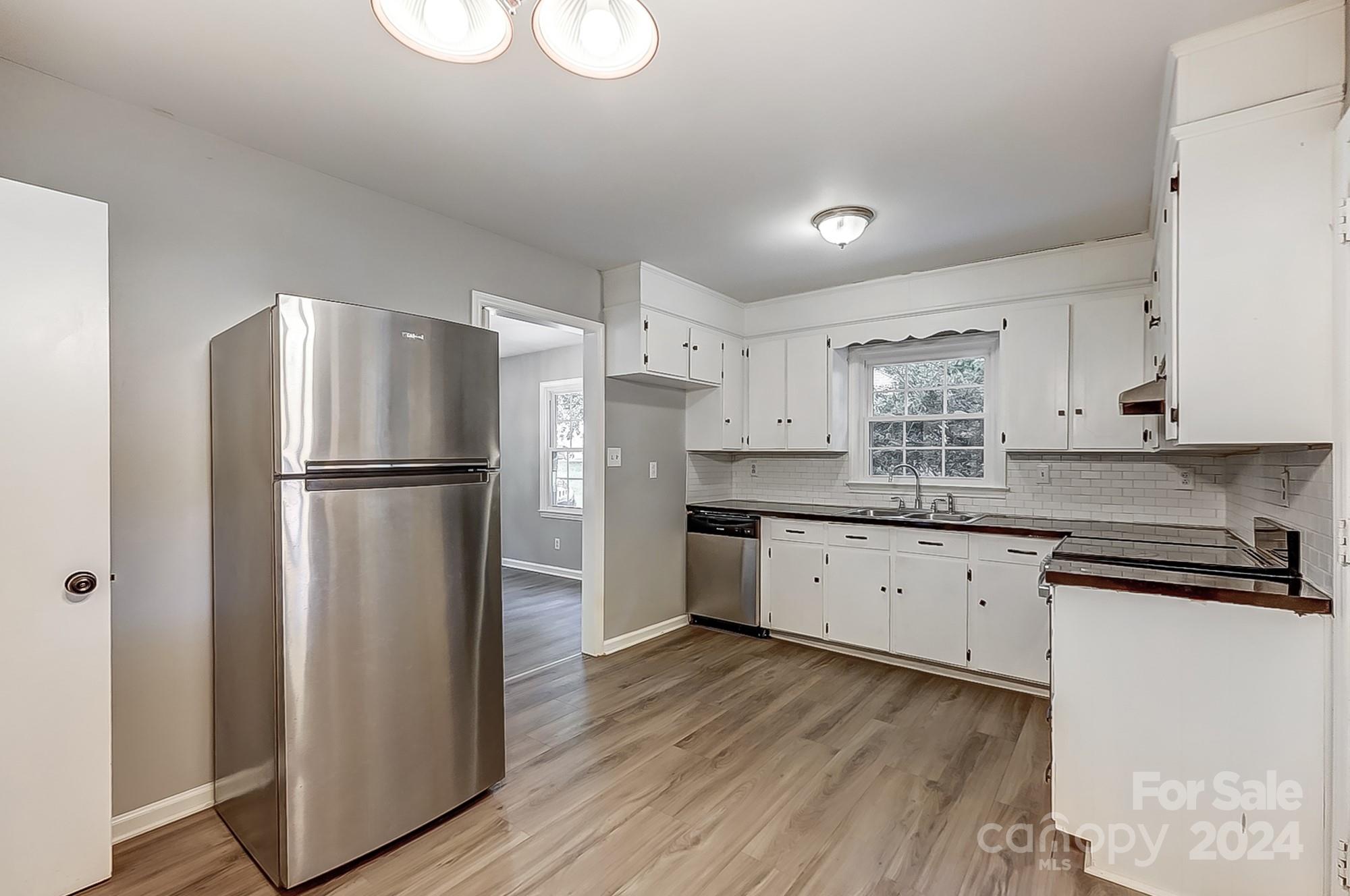 3218 Valley Grove Road Charlotte, NC 28227 - Photo 6 of 23 a kitchen with a refrigerator a sink and cabinets