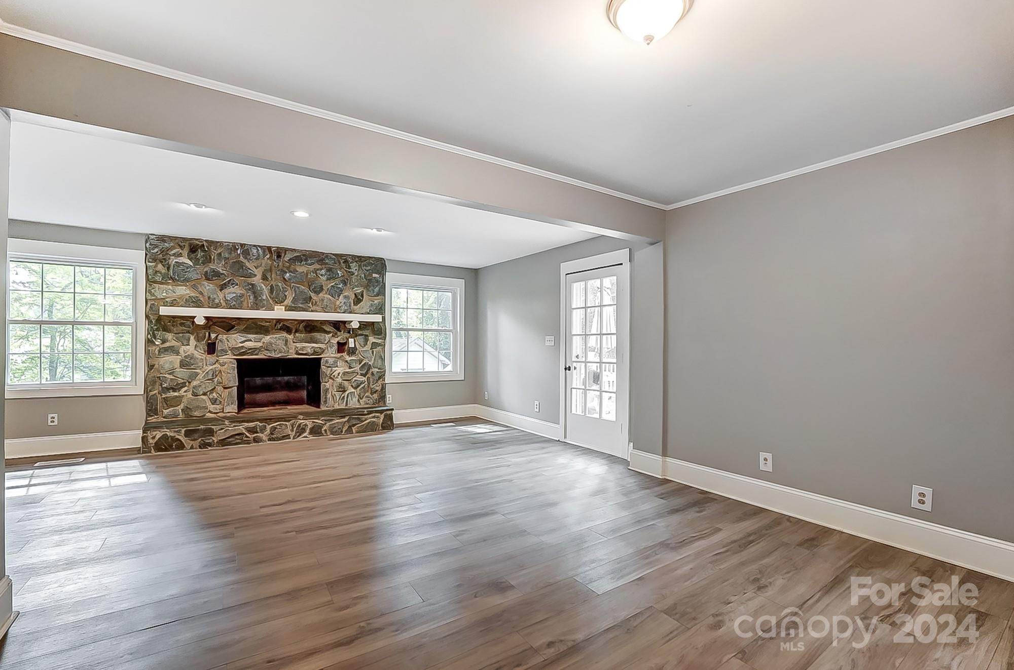 3218 Valley Grove Road Charlotte, NC 28227 - Photo 9 of 23 an empty room with wooden floor a fireplace and windows