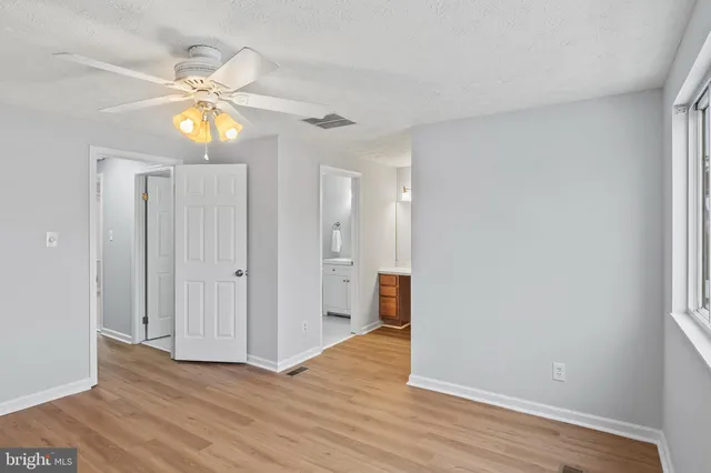 a view of a livingroom with a chandelier fan and wooden floor