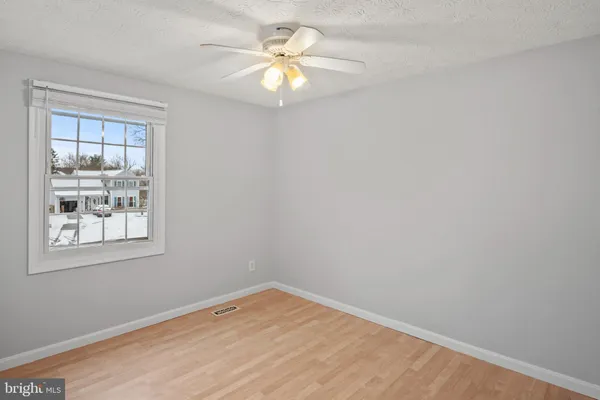 an empty room with a window and a fan
