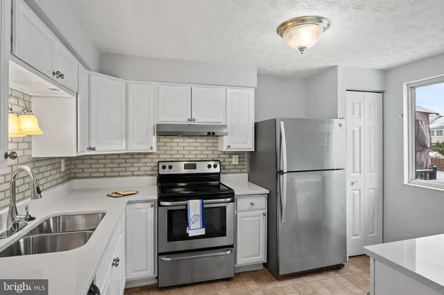 a kitchen with refrigerator a sink and cabinets