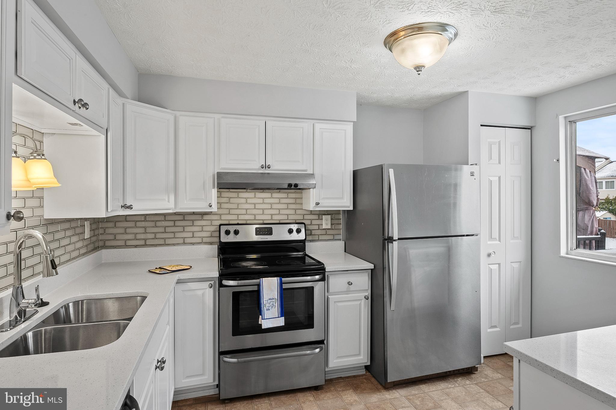 7346 Hidden Cove Columbia, MD 21046 - Photo 8 of 26 a kitchen with refrigerator a sink and cabinets