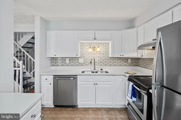 a kitchen with a sink stove and refrigerator