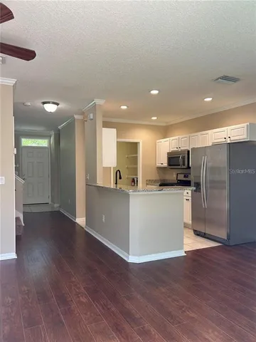 a view of kitchen with stainless steel appliances refrigerator microwave and stove