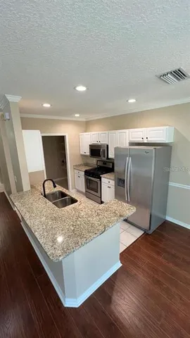 a kitchen with stainless steel appliances granite countertop a sink stove and wooden floor