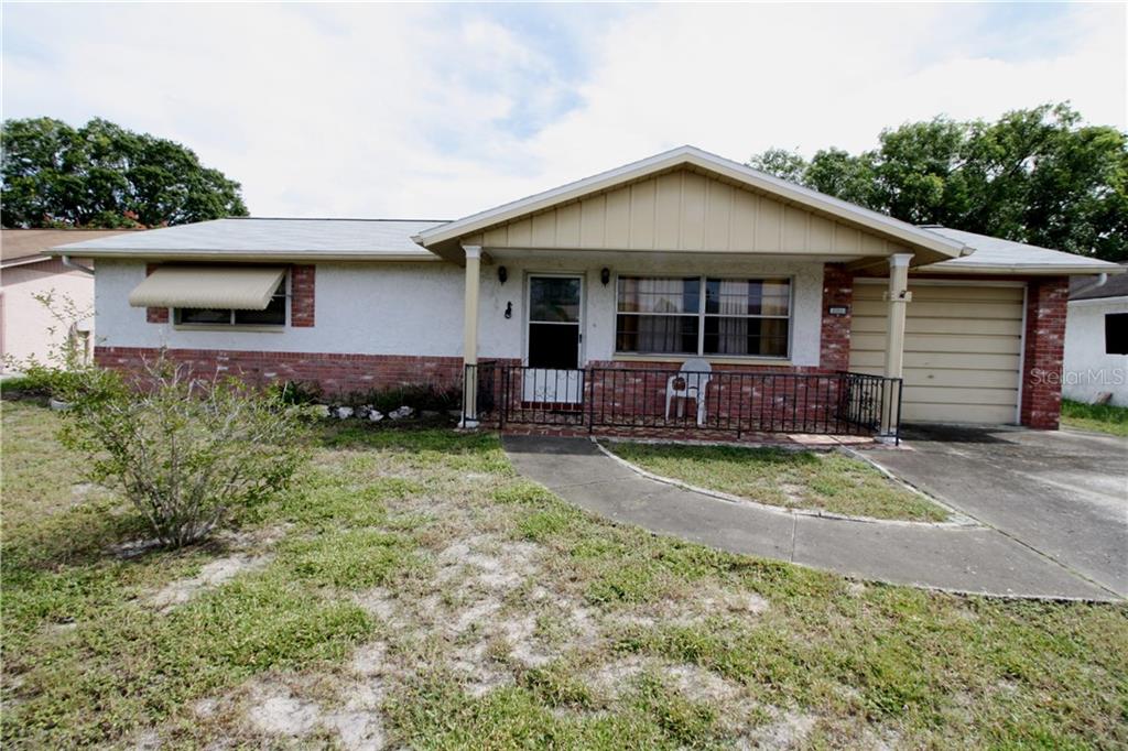8910 Cairo Lane Port Richey, FL 34668 - Photo 1 of 1 a front view of a house with garden