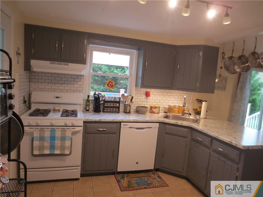 235 Maple Avenue Dunellen, NJ 08812 - Photo 11 of 20 a kitchen with stainless steel appliances a sink stove and cabinets