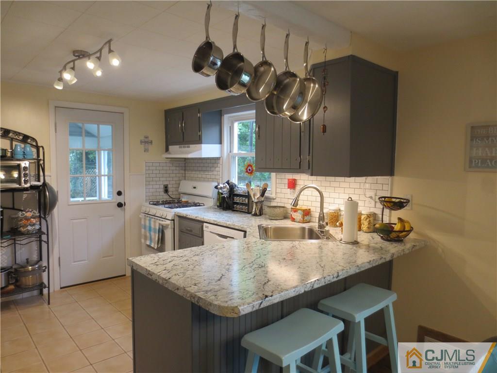 235 Maple Avenue Dunellen, NJ 08812 - Photo 12 of 20 a kitchen with kitchen island granite countertop a sink a counter space appliances and cabinets