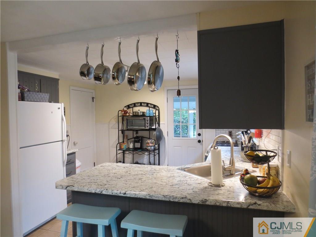 235 Maple Avenue Dunellen, NJ 08812 - Photo 13 of 20 a kitchen with granite countertop a refrigerator a stove and wooden floor