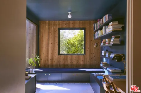 a bath room with a window and a book shelf