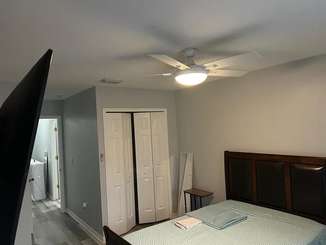 a bedroom with a bed and a flat tv screen on a dresser