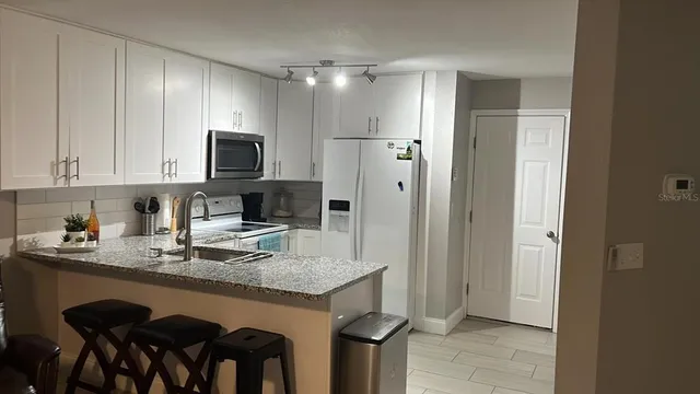 a kitchen with stainless steel appliances granite countertop a refrigerator and microwave