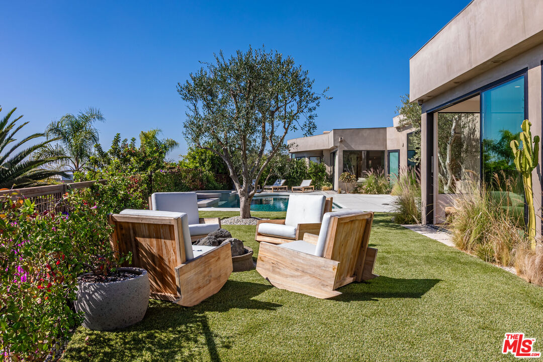 1705 Carla Ridge Beverly Hills, CA 90210 - Photo 32 of 39 a view of a chairs and table in backyard of the house