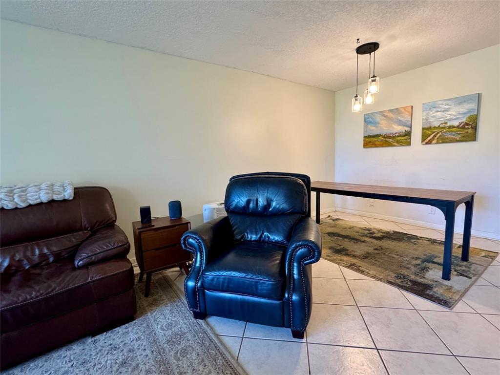 2601 South Course Drive, Unit 305 Pompano Beach, FL 33069 - Photo 11 of 20 a living room with furniture and a fireplace