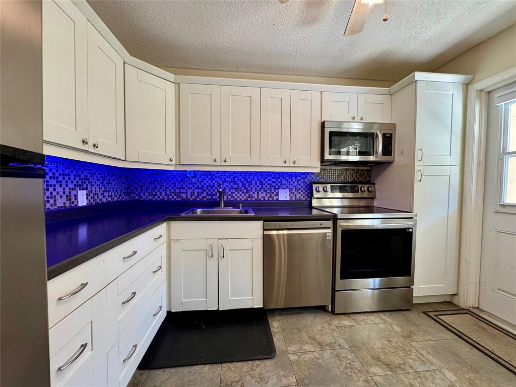 2601 South Course Drive, Unit 305 Pompano Beach, FL 33069 - Photo 19 of 20 a kitchen with stainless steel appliances white cabinets and a refrigerator