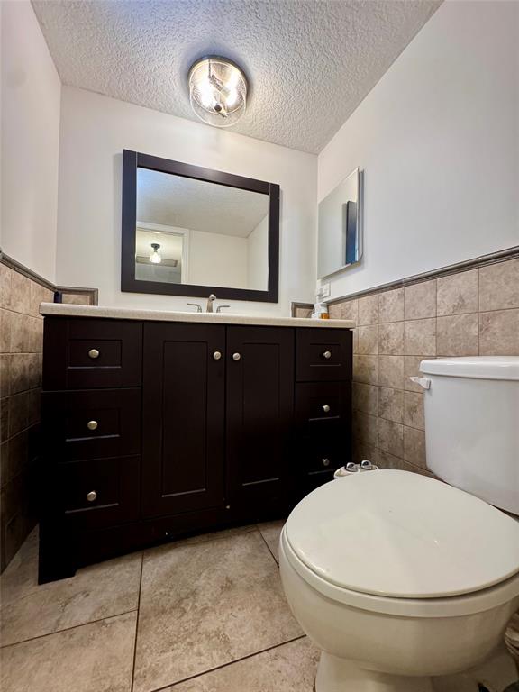 2601 South Course Drive, Unit 305 Pompano Beach, FL 33069 - Photo 7 of 20 a bathroom with a toilet a sink and mirror