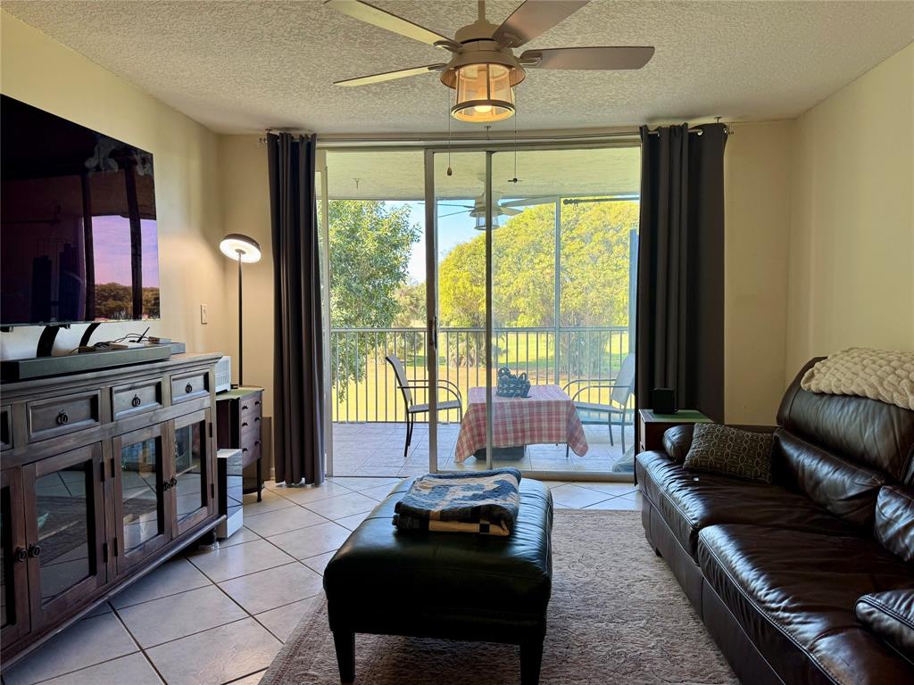 2601 South Course Drive, Unit 305 Pompano Beach, FL 33069 - Photo 10 of 20 a living room with furniture and a flat screen tv