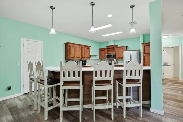 a view of a kitchen with stainless steel appliances windows refrigerator and chairs