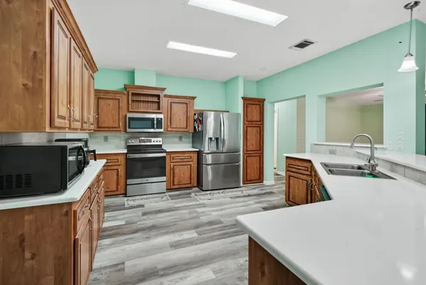 a kitchen with stainless steel appliances granite countertop a sink a stove and a refrigerator