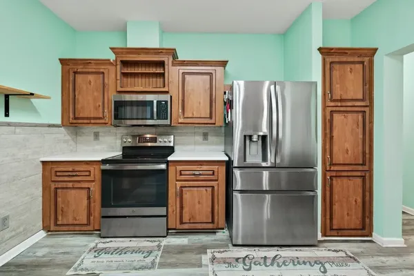 a kitchen with stainless steel appliances granite countertop a refrigerator stove and microwave