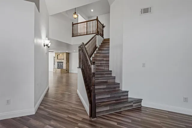 a view of a hallway with wooden floor and stairs