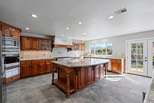 a kitchen with stainless steel appliances granite countertop a stove and a microwave
