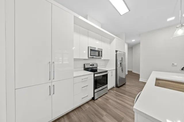 a kitchen with white cabinets and stainless steel appliances