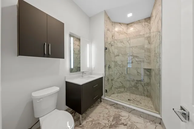 a bathroom with a bathtub shower sink mirror and toilet