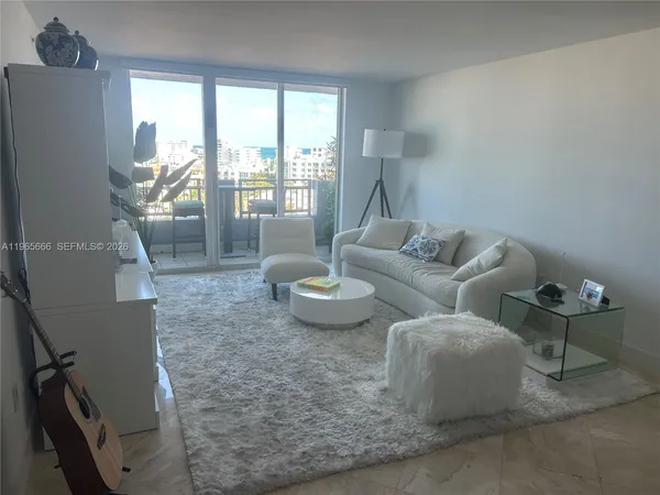 a living room with furniture and a floor to ceiling window