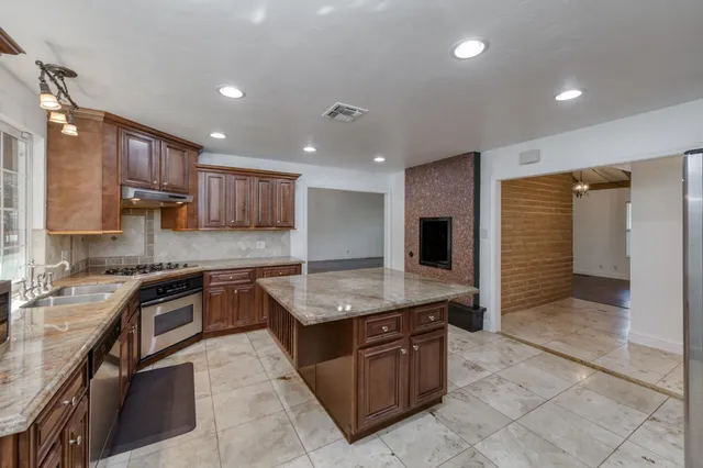 a kitchen with stainless steel appliances granite countertop a stove and a sink