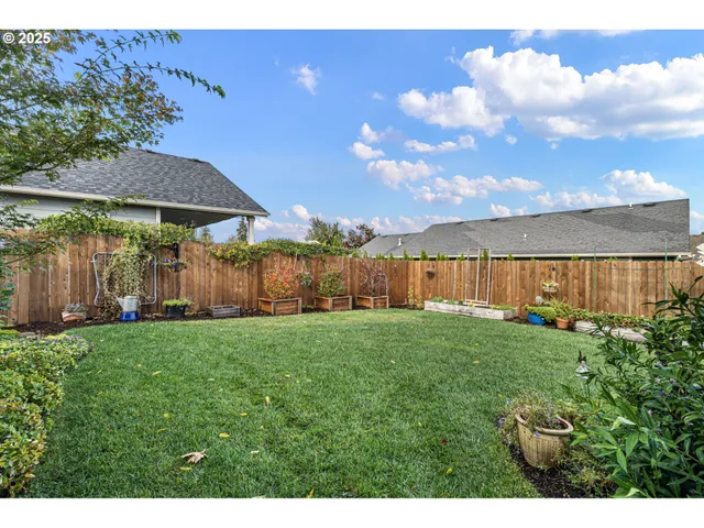 a view of a backyard with lawn chairs under an umbrella
