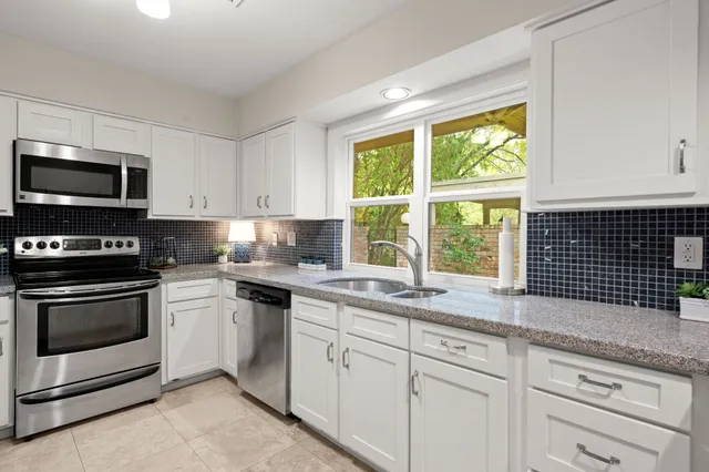 a kitchen with granite countertop a stove a sink and a microwave