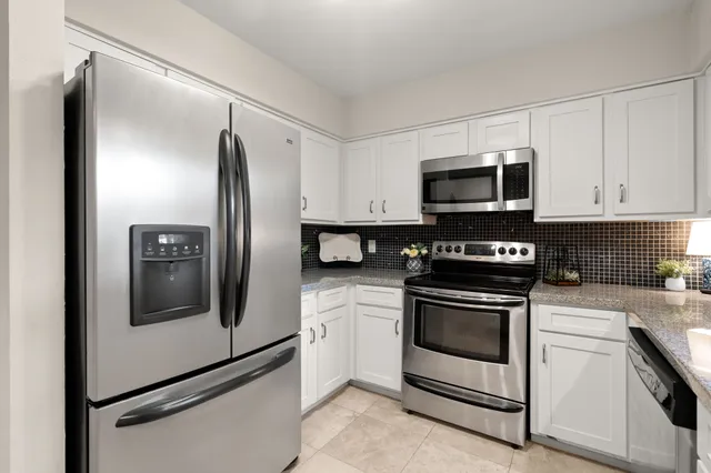 a kitchen with stainless steel appliances granite countertop a refrigerator stove and microwave