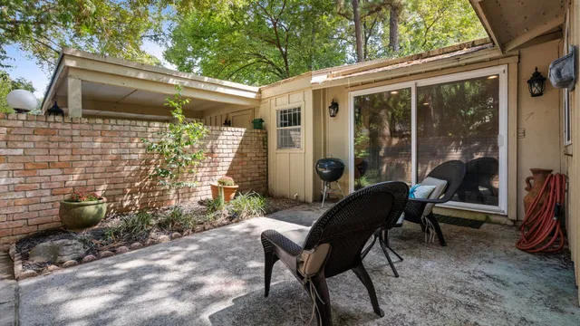 a view of a patio with table and chairs and wooden fence