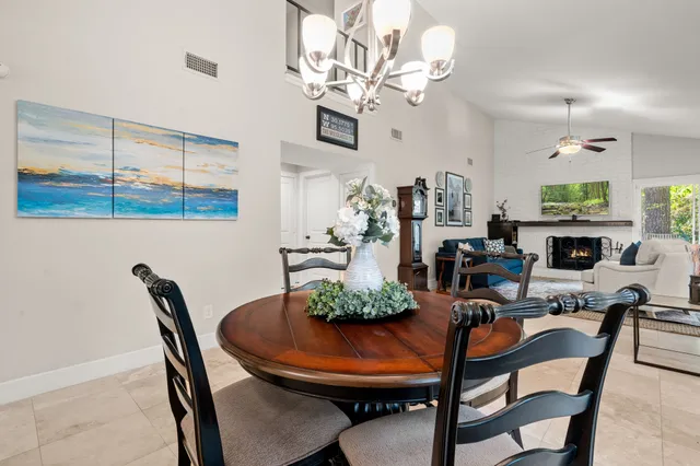 a view of a dining room with furniture a chandelier and a window