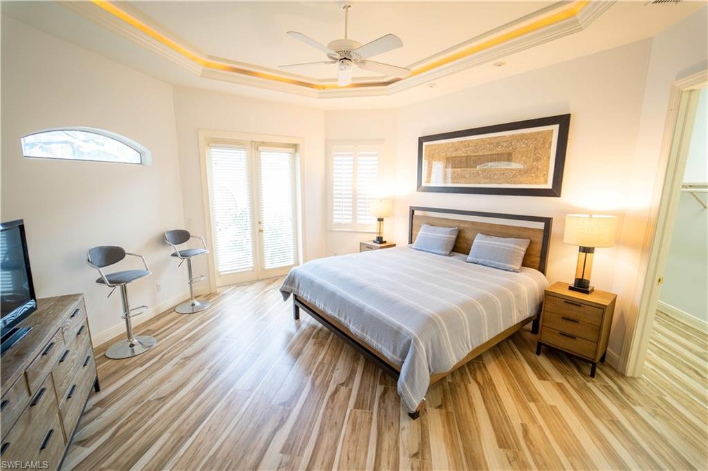 5886 Paradise Circle Naples, FL 34110 - Photo 9 of 19 Bedroom with a raised ceiling, ornamental molding, ceiling fan, and light hardwood / wood-style flooring