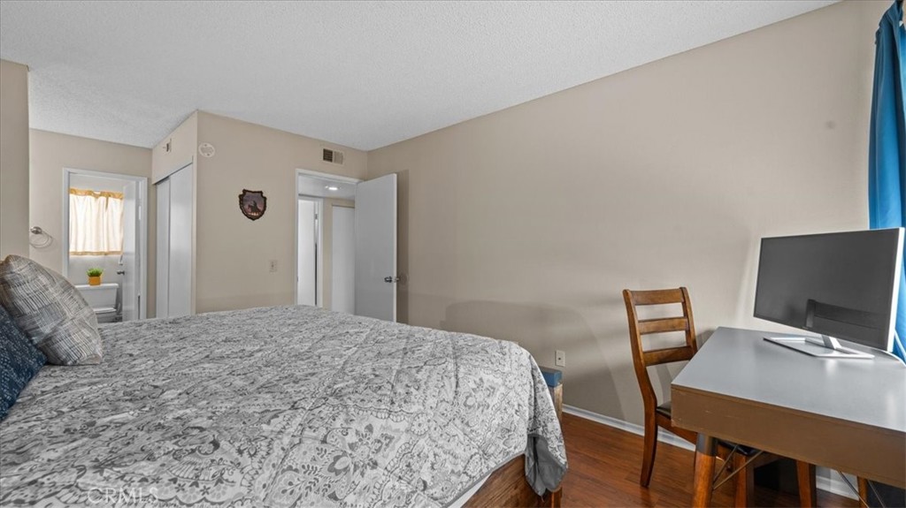 8425 Sunset Trail Place, Unit F Rancho Cucamonga, CA 91730 - Photo 11 of 28 a bedroom with a bed and a computer on a table