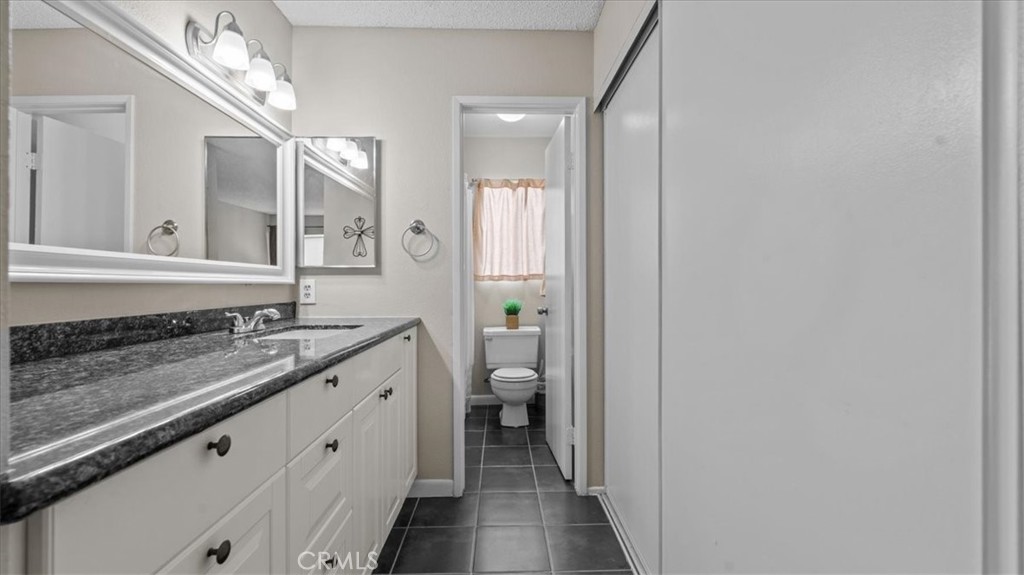 8425 Sunset Trail Place, Unit F Rancho Cucamonga, CA 91730 - Photo 12 of 28 a spacious bathroom with a granite countertop sink and a mirror