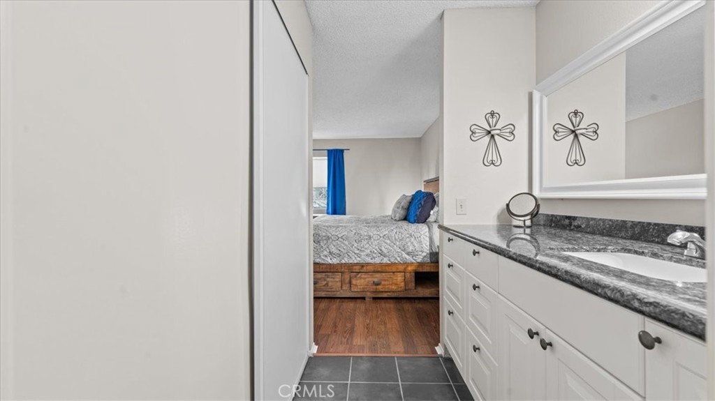 8425 Sunset Trail Place, Unit F Rancho Cucamonga, CA 91730 - Photo 13 of 28 a bathroom with a granite countertop sink and a mirror