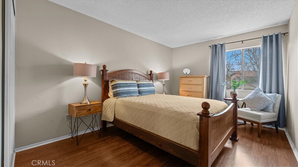 8425 Sunset Trail Place, Unit F Rancho Cucamonga, CA 91730 - Photo 14 of 28 a bedroom with a bed and wooden floor