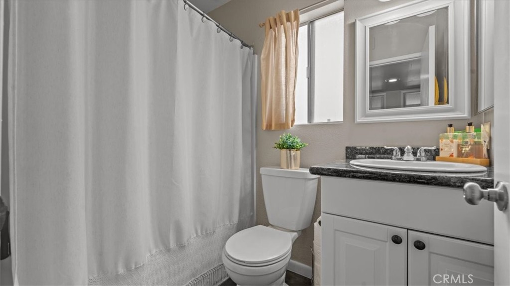 8425 Sunset Trail Place, Unit F Rancho Cucamonga, CA 91730 - Photo 15 of 28 a bathroom with a granite countertop toilet and sink