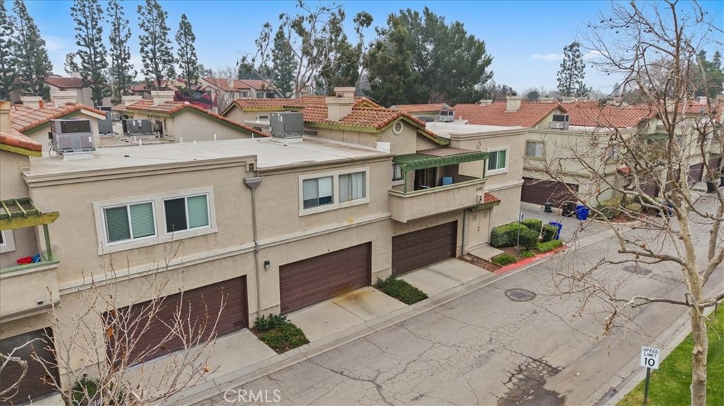 8425 Sunset Trail Place, Unit F Rancho Cucamonga, CA 91730 - Photo 23 of 28 a view of a white house with large windows and a small yard