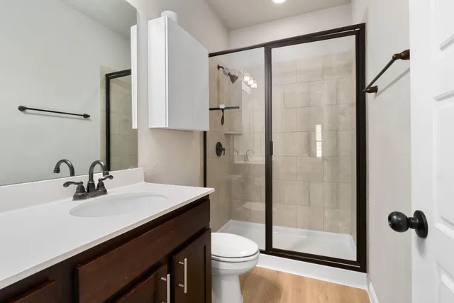 a bathroom with a sink a toilet and shower