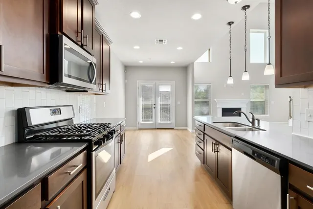 a kitchen with stainless steel appliances granite countertop a sink stove and cabinets