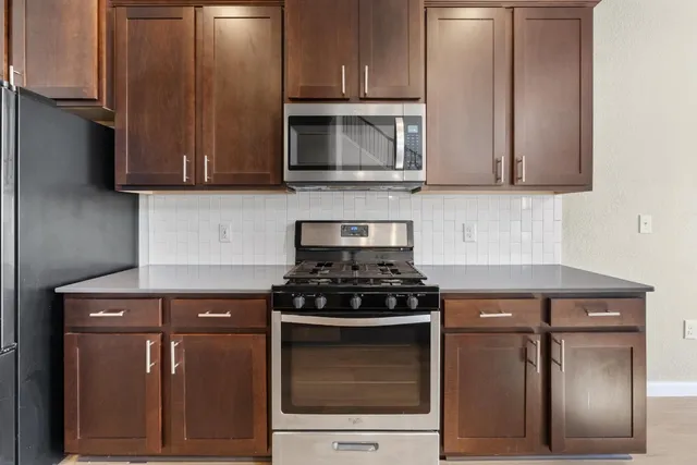a kitchen with granite countertop a stove and a microwave