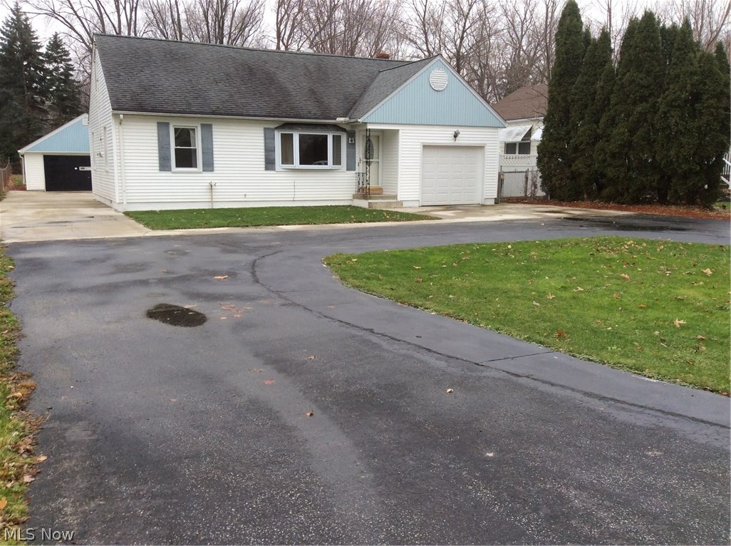 Circular drive accesses both the front entrance, 1 car attached garage, and 2 car detached garage.