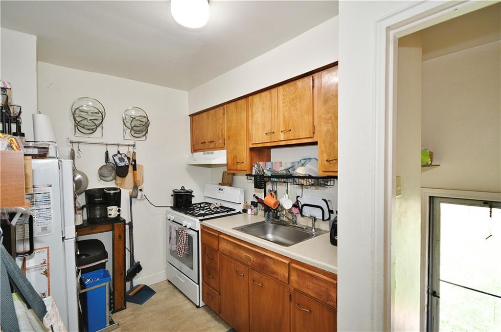569 Loretto Road Pittsburgh, PA 15217 - Photo 8 of 18 a kitchen with stainless steel appliances a stove a refrigerator a sink and cabinets