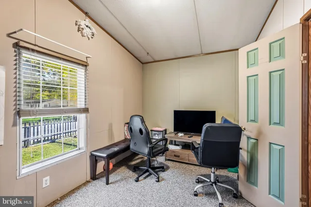 a view of a workspace with furniture and a window