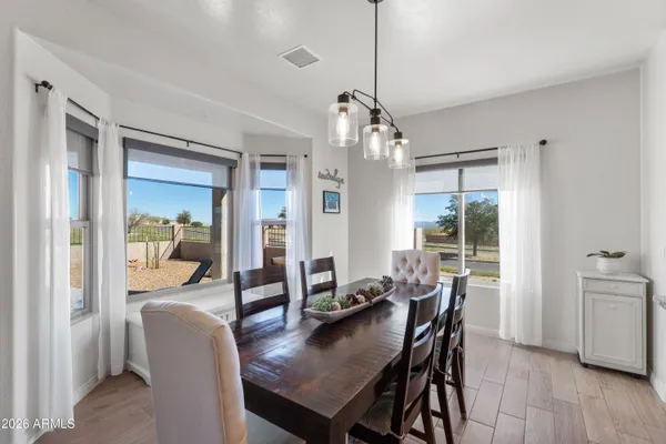 a view of a dining room and livingroom with furniture wooden floor a chandelier